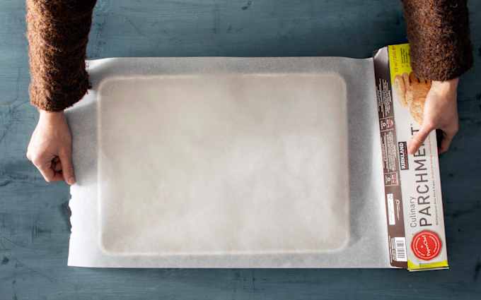 An oversize roll of parchment covers a half-sheet pan beneath it.